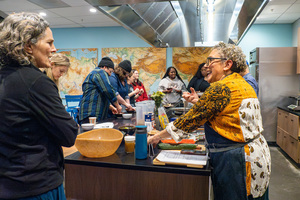 Naomi Kenealy, one of the hosts of the Kitchen Literacy Project, banters with a student during class. In the workshop, Kenealy showed participants how to create an Ayurvedic-styled late winter menu.